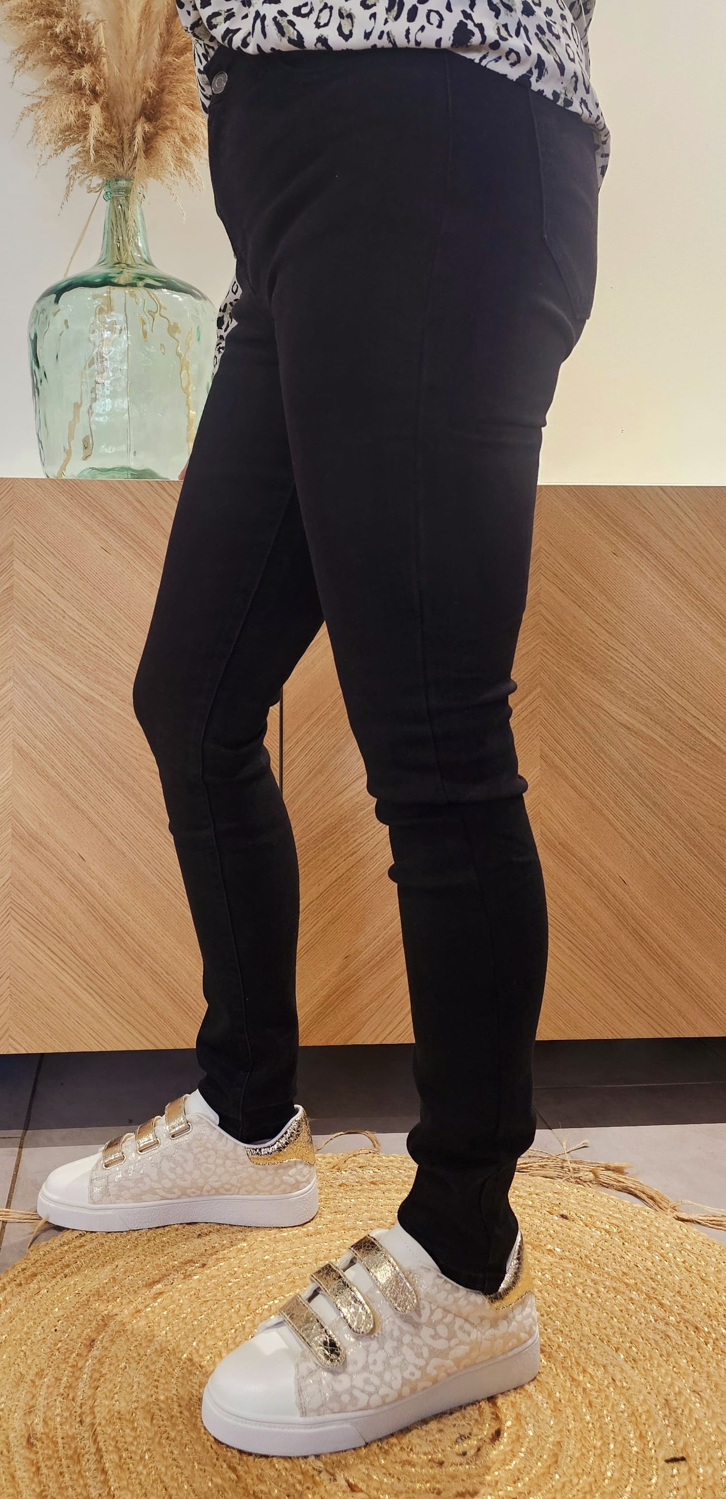 Le Jean slim Taille haute possède deux poches à l'avant et deux poches plaquées à l'arrière, ainsi qu'une fermeture par boutons et des passants pour ceinture.